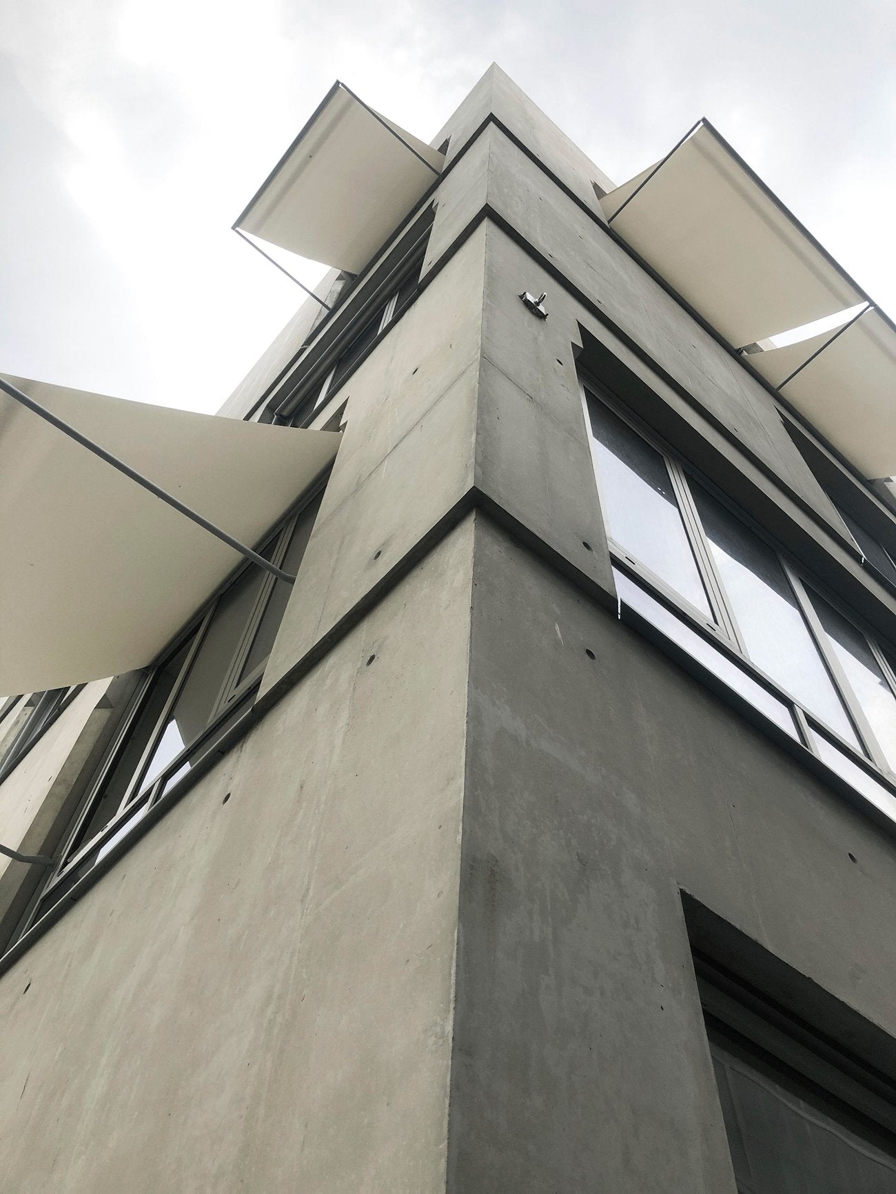 A building at Design District, Greenwich Peninsula, with large windows and bright green balconies